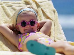 Criança na praia de óculos escuros